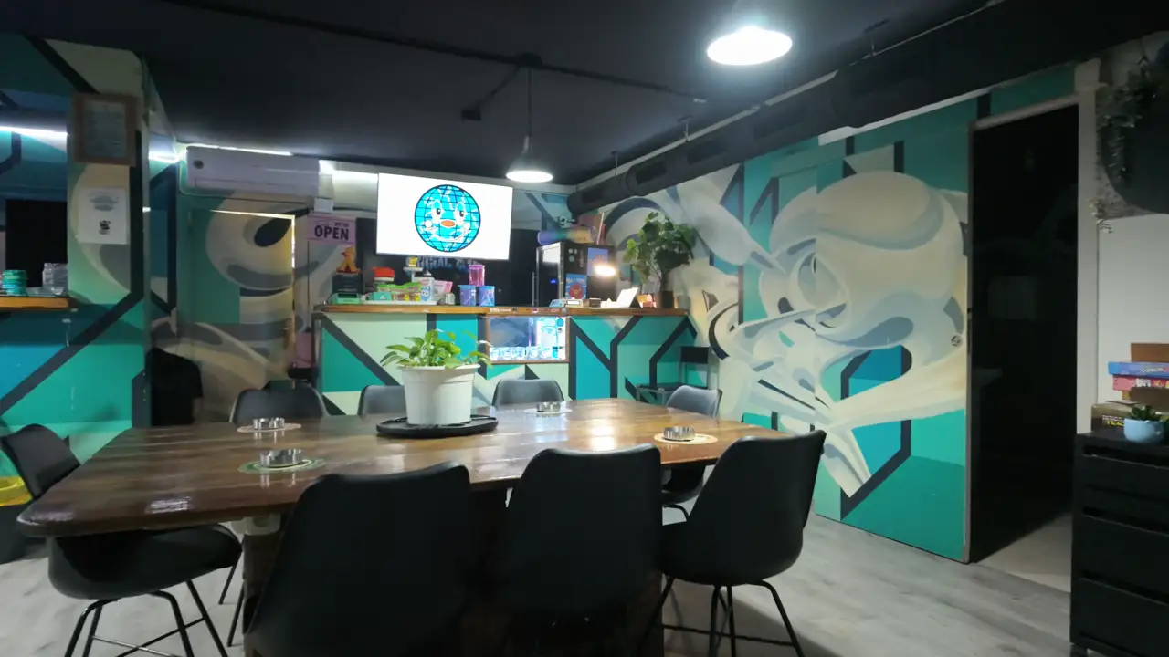 Interior de Alma Social Club: mesa comunal y murales